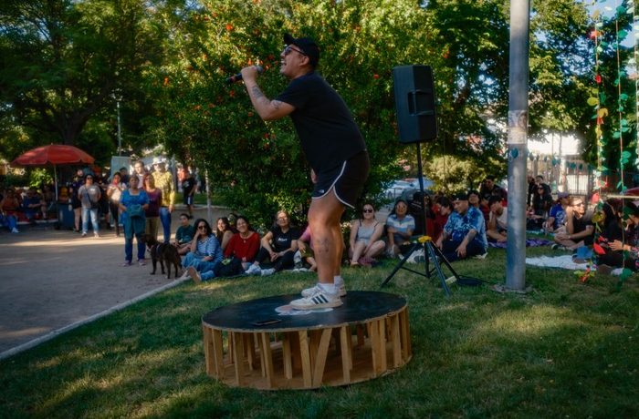 Comediante de Comedia Arbolitex haciendo stand-up al aire libre ante público sentado en el pasto
